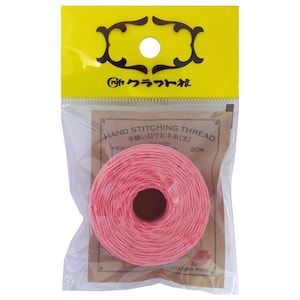 May include: A spool of sakura pink hand stitching thread packaged in a clear plastic bag with a yellow header. The label reads HAND STITCHING THREAD, 20M, and SAKURA PINK. The thread is wound into a circular shape with a hollow centre.