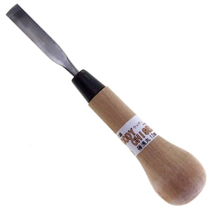 Könnte beinhalten: Ein Holzhobel mit einem Holzgriff, einer schwarzen Zwinge und einer silbernen Klinge. Der Griff trägt ein Etikett mit der Aufschrift "Woody Chisel 12mm".