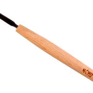 以下が含まれることがあります： V字型の刃を持つ木製の彫刻工具。ハンドルには日本語の文字が刻まれています。