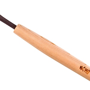 Puede incluir: Una herramienta de talla con mango de madera y hoja de metal negro. El mango está etiquetado con "林道" y "craft 18k".