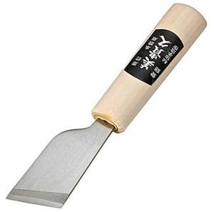 Puede incluir: Una pequeña herramienta de trabajo de cuero de color plateado con un mango de madera. El mango tiene texto japonés que dice "真鍮製 本革用" que se traduce como "Hecho de latón para cuero genuino".