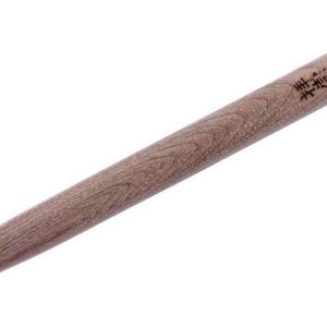 Puede incluir: Un cincel con mango de madera y una hoja de metal negro. El mango tiene texto japonés que dice "真鍮の", que se traduce como "latón".