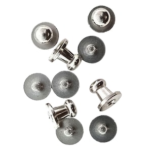 May include: A set of ten silver-toned metal snap fasteners. The fasteners have a round head and a post with a small, round base.