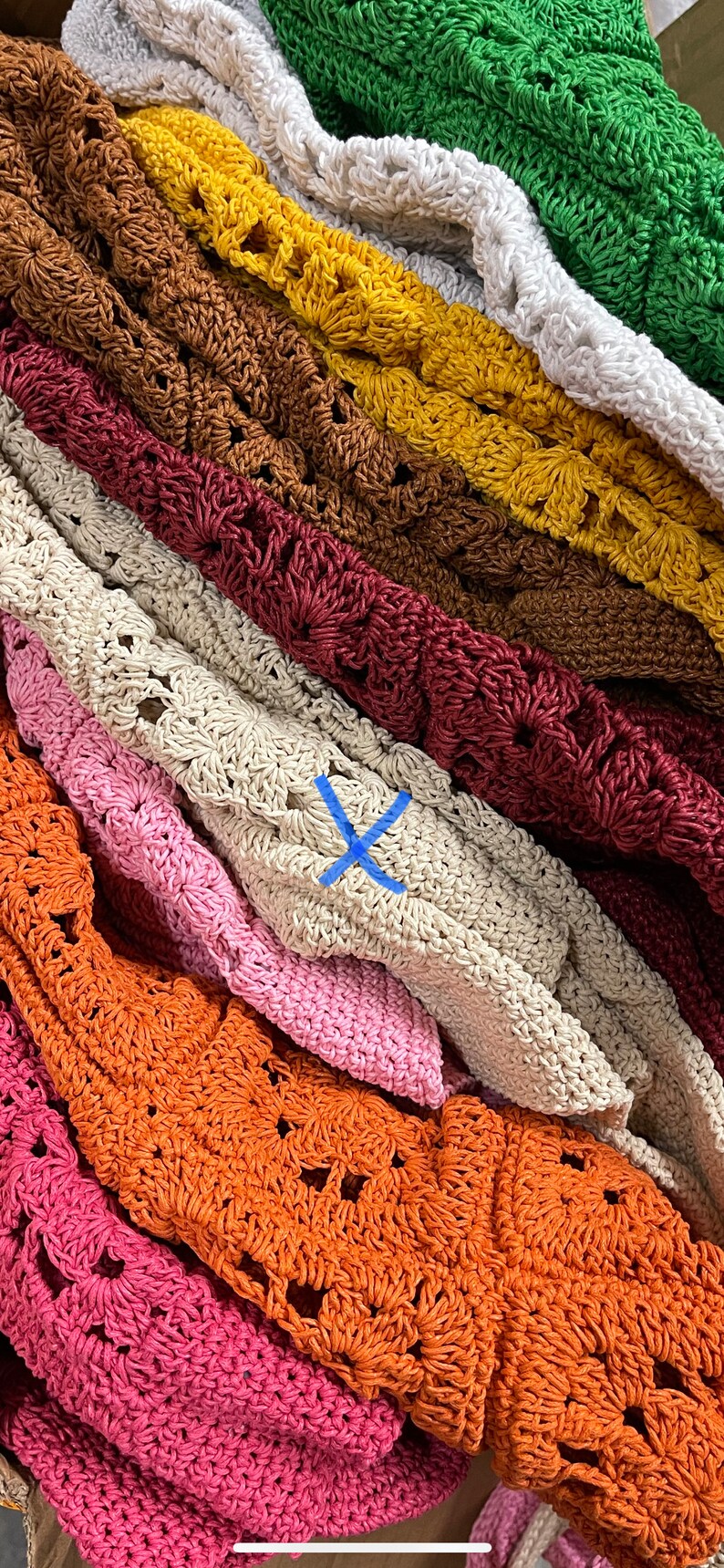 Puede incluir: Una pila de bolsos de crochet en varios colores, incluyendo verde, blanco, marr&oacute;n, amarillo, rojo, beige, rosa, naranja y rosa oscuro. Los bolsos est&aacute;n hechos con un patr&oacute;n delicado y de tejido abierto.