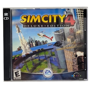 May include: SimCity 4 Deluxe Edition PC game in a clear plastic case. The cover art features a cityscape with a rocket launch, helicopter, and various buildings. The game is rated "Everyone" by the ESRB and includes two CDs.