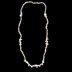 May include: A long necklace composed of small, off-white, irregularly shaped natural seashells strung together in a continuous loop. The shells vary slightly in size and texture, creating a delicate, organic appearance throughout the strand.
