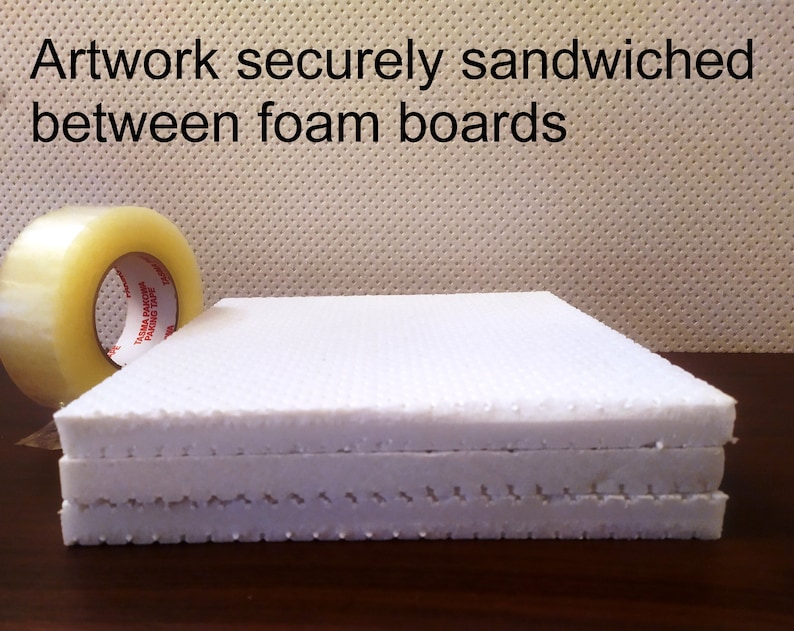 May include: White foam boards stacked together, with a roll of clear packing tape in the background. The text "Artwork securely sandwiched between foam boards" is visible at the top.