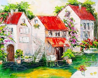 May include: An impressionistic painting of European-style buildings with red roofs and white walls. The artwork depicts a sunny scene with lush greenery, flowers, and a cafe setting. The painting has a textured, layered appearance, with visible brushstrokes.