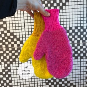 May include: Two knitted mittens, one yellow and one vibrant pink, are held up against a black and white chequered backdrop. The mittens have a fluffy, textured look. The text "pdf knitting pattern" is in a white circle.