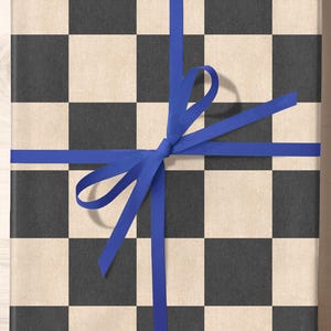 May include: A gift box wrapped in black and white checkered paper with a blue ribbon tied in a bow.