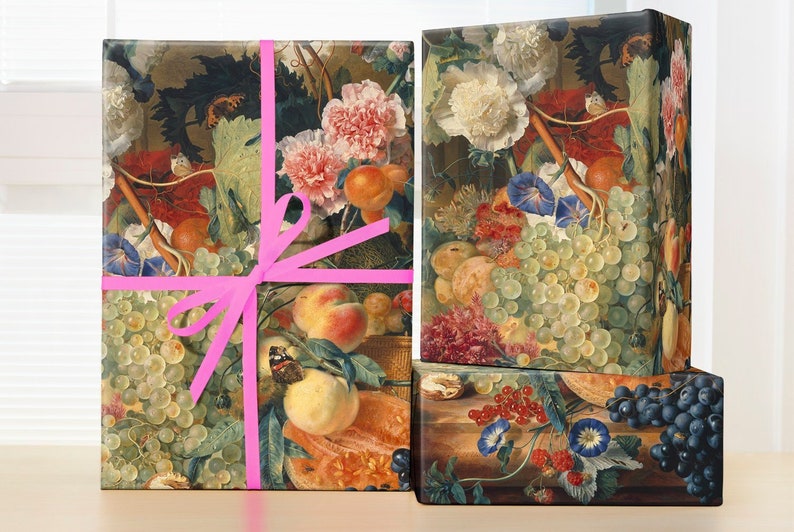 May include: Three gift boxes wrapped in vintage floral patterned paper. The boxes are tied with a pink ribbon. The paper features a still life of fruit, flowers, and leaves.