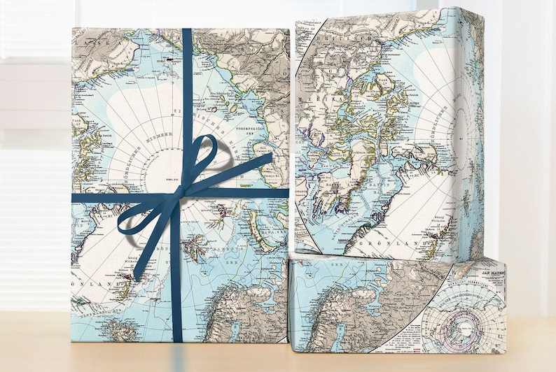 May include: Three gift boxes wrapped in vintage style world map wrapping paper. The boxes are tied with blue ribbon and bows. The maps are in shades of blue, brown, and white. The boxes are sitting on a wooden surface.