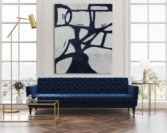 May include: A blue velvet sofa with tufted upholstery sits in a modern living room with a large abstract painting above it. The painting features a white background with black and blue lines and shapes. The room also has a gold floor lamp, a glass coffee table, and a side table with a lamp.