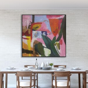 May include: Abstract painting in a black frame with pink, red, yellow, green, and blue colors. The painting is hanging on a white brick wall above a dining table with six chairs.