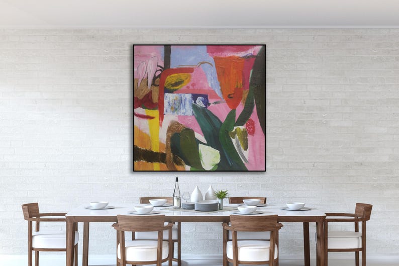 May include: Abstract painting in a black frame with pink, red, yellow, green, and blue colors. The painting is hanging on a white brick wall above a dining table with six chairs.