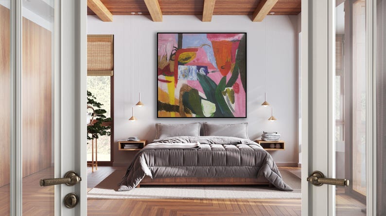 May include: A bedroom with a large abstract painting above the bed. The painting features a pink, green, yellow, and red color scheme. The bed has a gray comforter and is made up with white pillows. The room has wooden floors and a wooden ceiling.