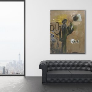 Puede incluir: Pintura abstracta con colores marrones, amarillos y verdes. La pintura presenta una gran forma abstracta en el centro, rodeada de formas y l&iacute;neas m&aacute;s peque&ntilde;as. La pintura est&aacute; enmarcada en un marco negro y cuelga de una pared blanca.