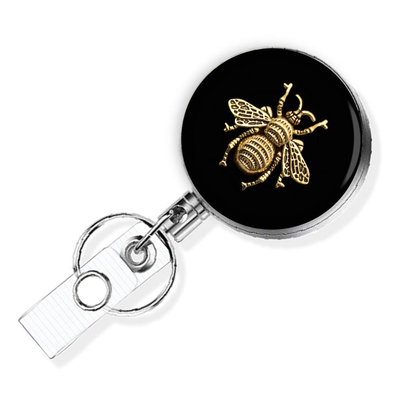 a black and gold badge with a bee on it