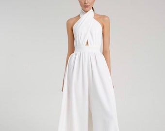 May include: A white halter jumpsuit with a criss-cross neckline and a wide leg silhouette.