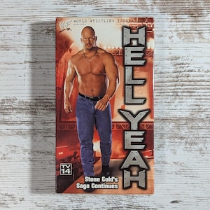 May include: A VHS tape featuring Stone Cold Steve Austin, with the text "HELL YEAH" in large, bold letters. The cover shows a shirtless man in jeans, with the words "Stone Cold's Saga Continues". The tape is labeled "TV 14".