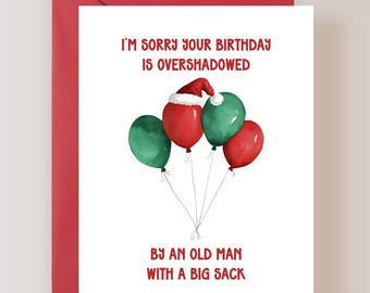May include: A white greeting card with red text that reads I'M SORRY YOUR BIRTHDAY IS OVERSHADOWED BY AN OLD MAN WITH A BIG SACK. The card features a watercolor illustration of red and green balloons, one wearing a red Santa hat.