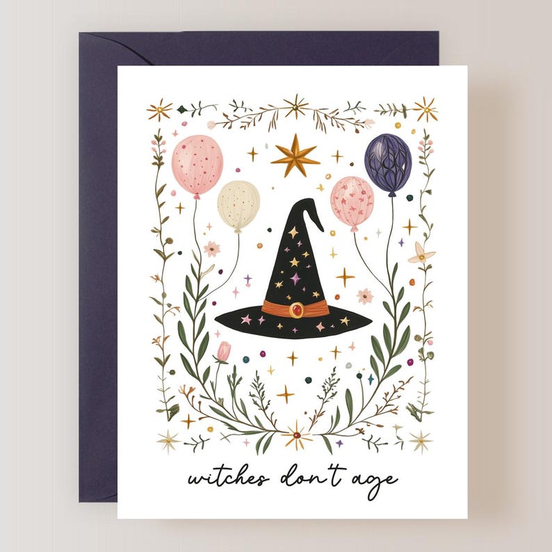 May include: A white card with a black witch's hat surrounded by green leaves, pink, white, and purple balloons, and gold stars. The text "witches don't age" is at the bottom of the card.
