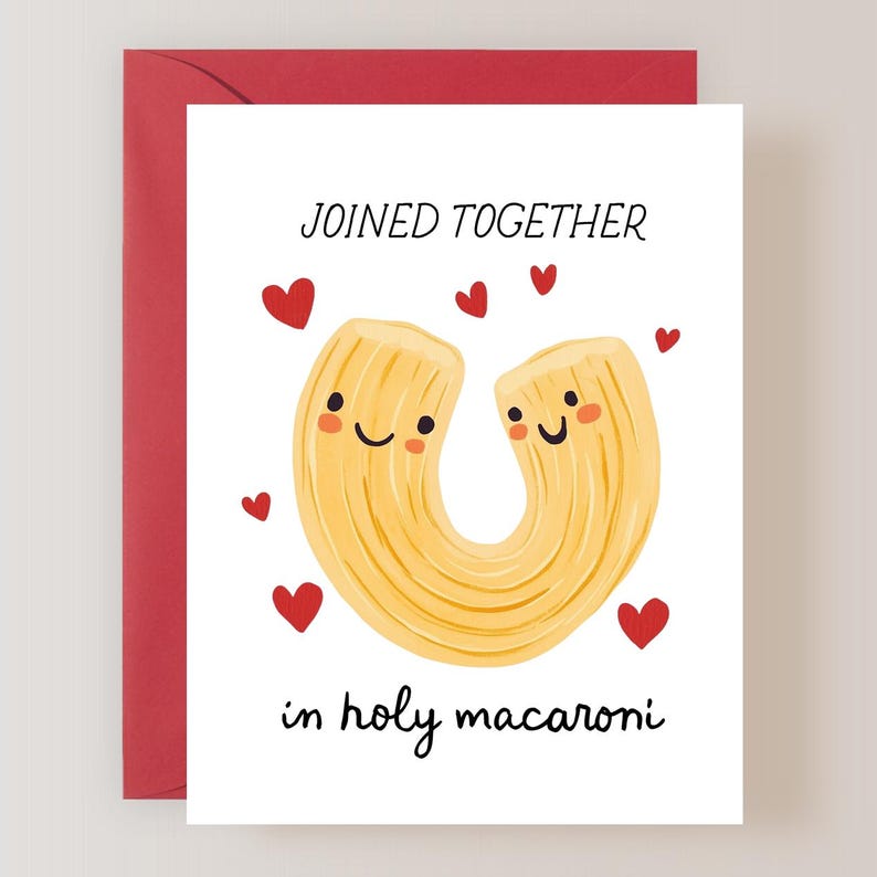 May include: A white greeting card with a red envelope. The card features two smiling cartoon pasta shapes with red hearts and the text "JOINED TOGETHER in holy macaroni."