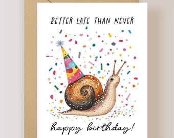 May include: A white greeting card featuring a snail wearing a colorful party hat, surrounded by multi-colored confetti. The text reads BETTER LATE THAN NEVER at the top and happy birthday! at the bottom, with a brown envelope behind it.