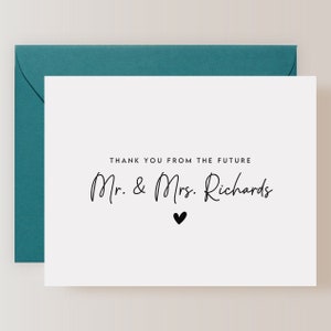 May include: White card with black text that reads "Thank you from the future Mr. & Mrs. Richards" with a small black heart below the text.