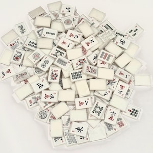 May include: A collection of white Mahjong tiles with black and red symbols and characters. The tiles are scattered, showing various suits, numbers, and winds. Some tiles have floral designs.