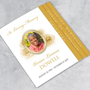 May include: A white memorial booklet with a gold border and a photo of a woman in a white oval frame. The booklet has the text "In Loving Memory" at the top and "Vivian Leanna Dowell" in a gold script font. The dates "August 21, 1950 - October 27, 2019" are printed below the name. The booklet has tabs on the right side with the words "Loving Memories", "Order of Service", and "Obituary".
