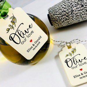May include: Olive oil bottle with a white tag that says "Olive our love" with a red heart and the text "Elisa & Gerald 09.09.2018".