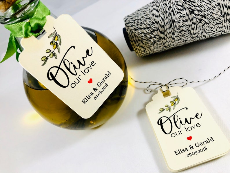 May include: Olive oil bottle with a white tag that says "Olive our love" with a red heart and the text "Elisa & Gerald 09.09.2018".