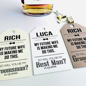 May include: Three gift tags with brown and white paper stock. The tags have black text that reads "My future wife is making me do this." and "So will you be my ...?" with the options "Groomsman?" or "Best Man?" and the date "11.13.20XX".