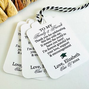 May include: White graduation favor tags with black text. The text reads "To My Family & Friends Thank you for celebrating this day with me. It means the world to have you here! I'm forever grateful for your love, support & encouragement Love, Elizabeth Class of 20xx"