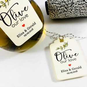 May include: Olive branch design wedding favor tag with the text "Olive our love" and the names "Elisa & Gerald" and the date "09.09.2018".