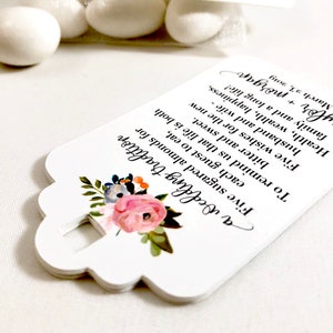 Puede incluir: Etiqueta de favor blanca con un dise&ntilde;o floral y el texto "a Wedding tradition Five sugared almonds for each guest to eat, bitter and sweet. To remind us that life is both Five wishes for the new husband and wife - Health, wealth, happiness, family and a long life! taylor + morgan 23, 2019"