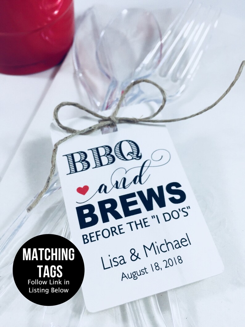 May include: White tag with black text that reads "BBQ and BREWS BEFORE THE "I DO'S" Lisa & Michael August 18, 2018". The tag is tied to a clear plastic fork and spoon.