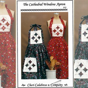May include: Aprons with a "Cathedral Window" design, displayed on mannequins. One apron is red with a floral pattern, the other is dark green with a floral pattern. The aprons have a white square bib with a diamond pattern. The text "The Cathedral Window Apron" is visible.