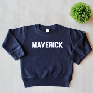 May include: A navy blue sweatshirt with the word "MAVERICK" printed in white on the front.