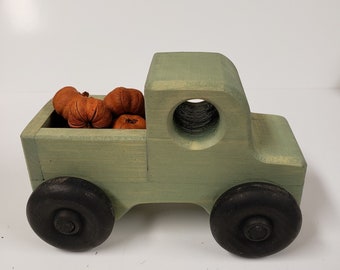 Camioneta vintage de madera verde hecha a mano con calabazas. Decoración de Halloween.