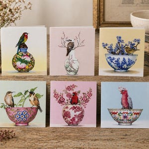 May include: A collection of six square greeting cards, each with a detailed illustration of birds on decorative vases and bowls. The cards feature colourful birds and floral designs, ideal for sending a thoughtful message.