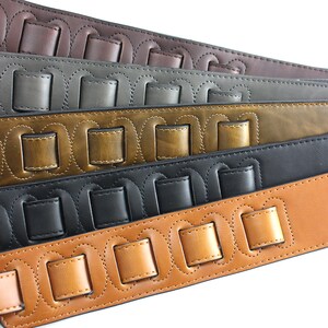 Puede incluir: Cinco correas de guitarra en diferentes colores, cada una con un dise&ntilde;o &uacute;nico de cuadrados de cuero cosidos. Las correas est&aacute;n hechas de cuero marr&oacute;n, gris, marr&oacute;n claro, negro y marr&oacute;n.