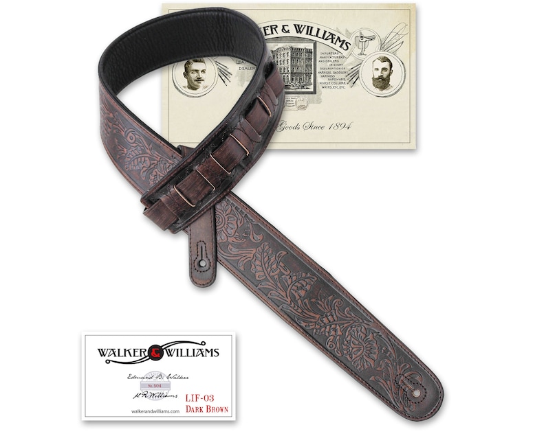 Puede incluir: Una correa de guitarra de cuero marr&oacute;n oscuro con un intrincado dise&ntilde;o floral. La correa est&aacute; estampada con el texto "Walker & Williams Goods Since 1894".