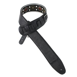 Pu&ograve; includere: Cinturino per chitarra in pelle nera con un design a motivi bianchi e marroni. Il cinturino ha una fila decorativa di borchie metalliche e una fibbia.