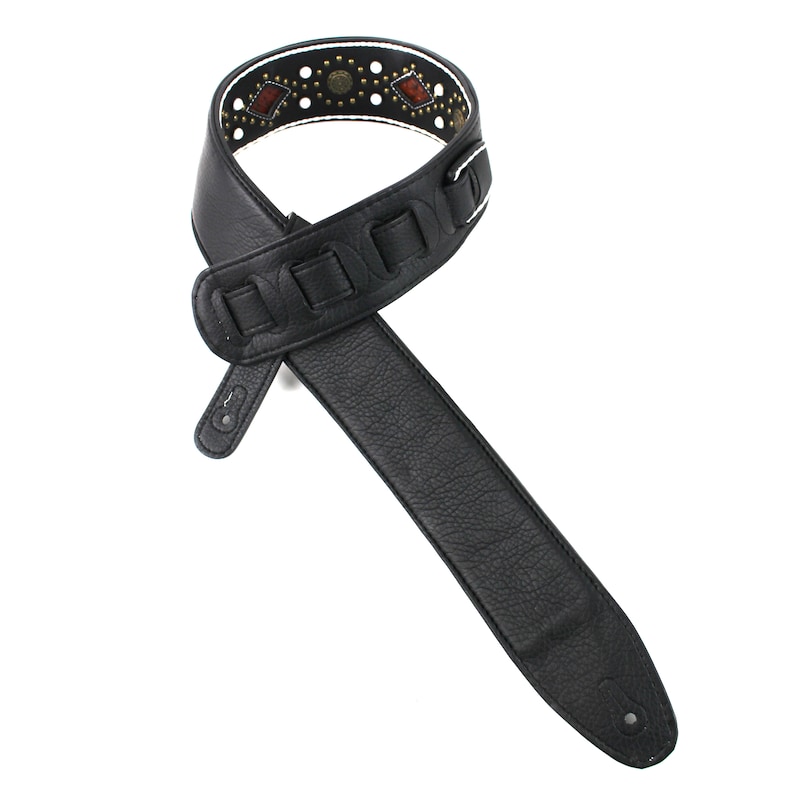 Pu&ograve; includere: Cinturino per chitarra in pelle nera con un design a motivi bianchi e marroni. Il cinturino ha una fila decorativa di borchie metalliche e una fibbia.