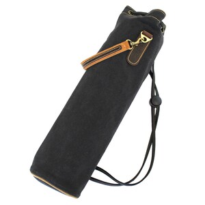 May include: A black canvas drawstring bag with a brown leather strap and a brass buckle. The bag has a black drawstring closure and a black strap with a black plastic buckle.