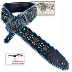 May include: A black leather guitar strap with turquoise and gold accents. The strap has a diamond pattern and the text "Walker & Williams" is embossed on the strap.