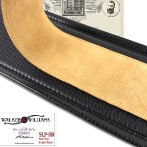 May include: Close-up of a black leather guitar strap with a brown suede strip. The strap is stitched with yellow thread. The strap is labeled "SLP-SB Non Slip Suede Strip" and "Walker & Williams".