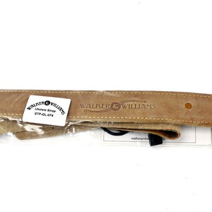 Peut inclure: Une sangle de guitare en cuir marron avec le texte "Walter & Williams" en relief. La sangle est emball&eacute;e dans un sac en plastique transparent.